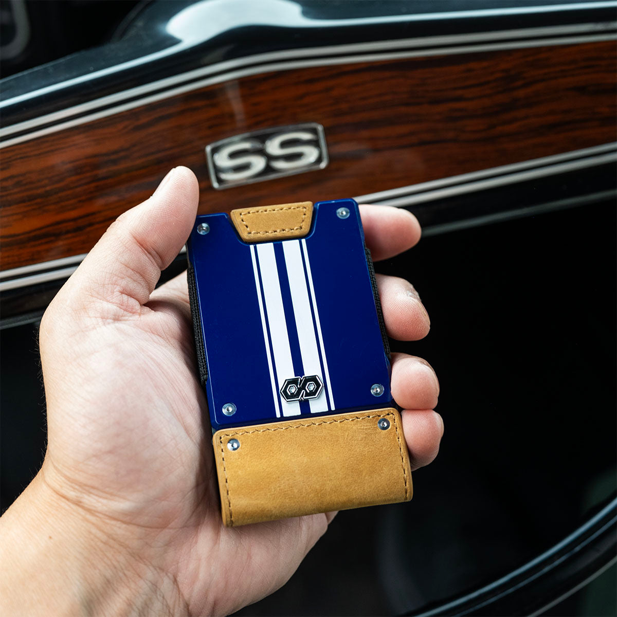 Hand holding the PROOF Octane tobacco leather wallet inside a 1969 Camaro Z10