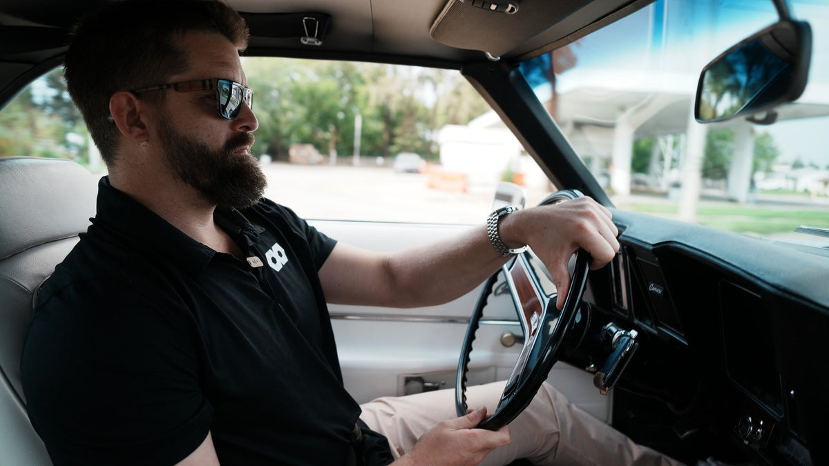 Behind the wheel of the 1969 Camaro Z10, white interior and woodgrain steering wheel