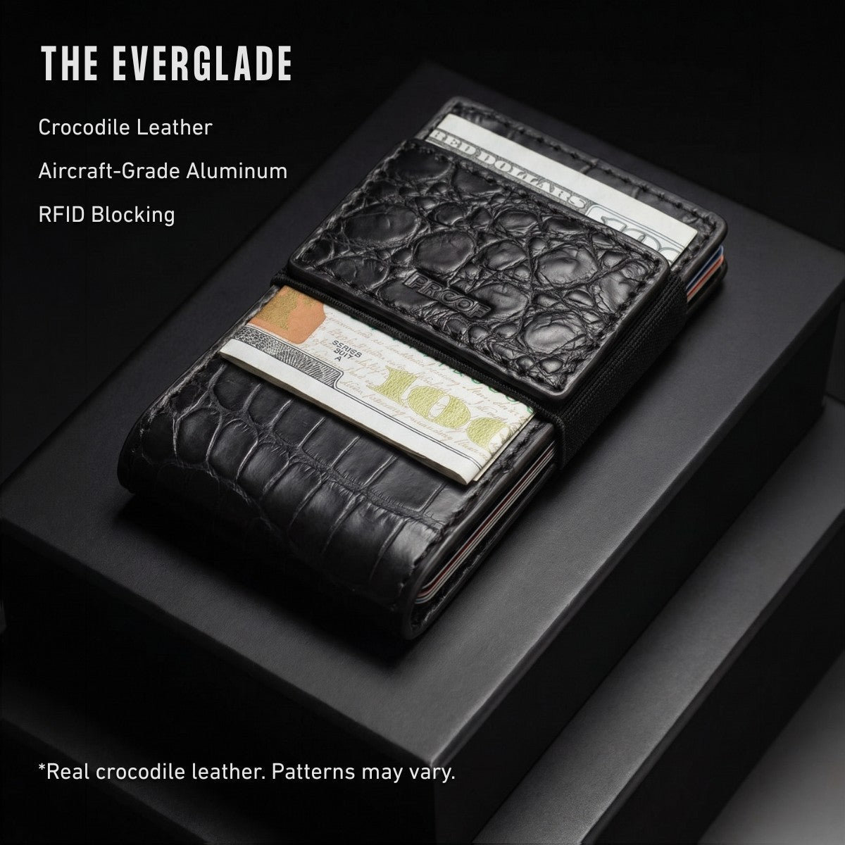 A black crocodile leather card holder wallet with visible texture, shown partially open on a dark display surface. Text on the image reads 'THE EVERGLADE' and lists features including crocodile leather, aircraft-grade aluminum, RFID blocking, and a note that real crocodile leather patterns may vary.